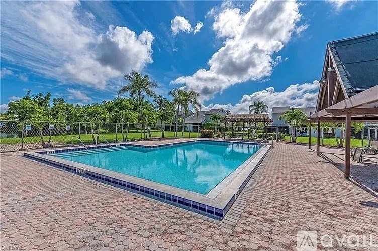 A large outdoor swimming pool surrounded by a brick patio.