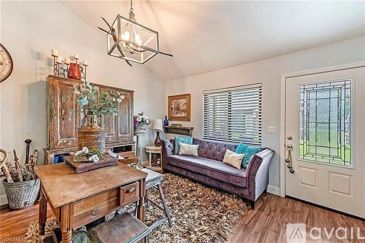 A living room with a couch, a table, and a chandelier.