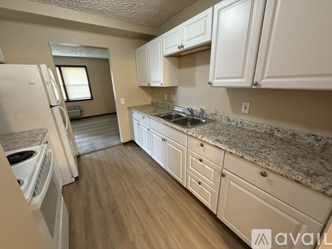 A kitchen with white cabinets and granite countertops.