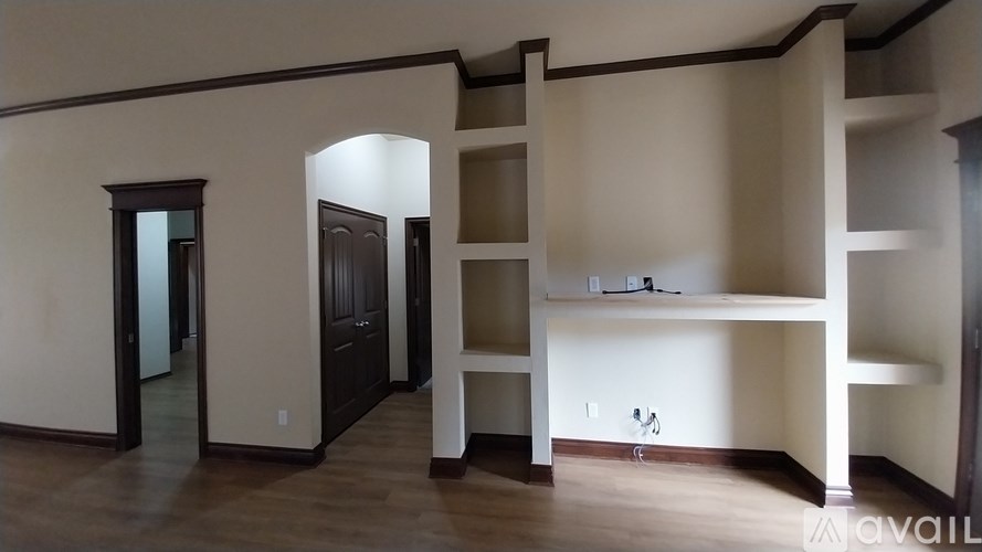 A room with a white wall and a wooden floor.