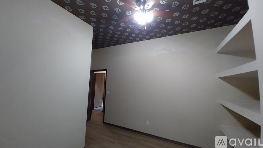 A room with a ceiling covered in circular patterns and a staircase on the right side.
