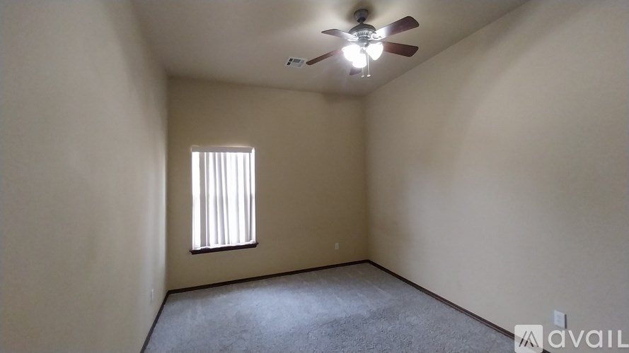 A room with a ceiling fan and a window with blinds.