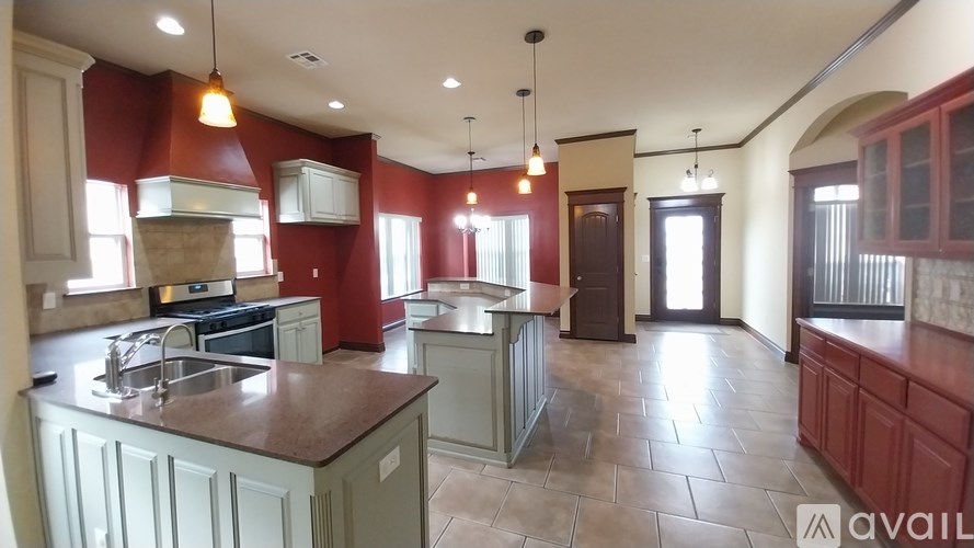 A kitchen with red walls and a large island.