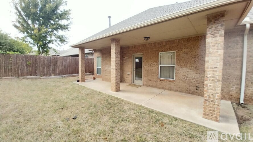 A house with a brown brick exterior and a covered patio area.