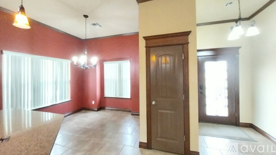 A room with a brown door and a chandelier.