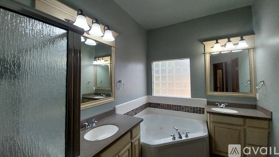 A bathroom with a tub, sink, and mirror.