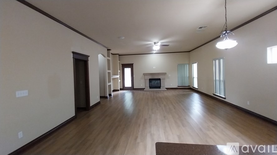 A spacious living room with a fireplace and hardwood floors.