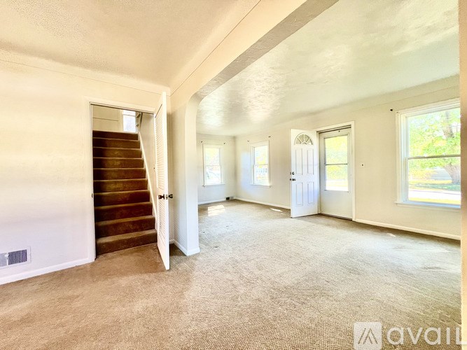 A spacious room with a staircase leading to another level.