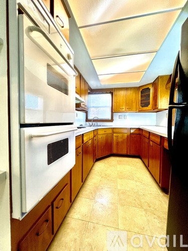 A kitchen with wooden cabinets and a white fridge.