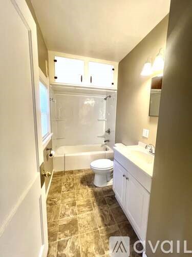 A bathroom with a toilet, sink, and bathtub.