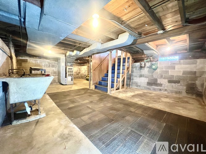 A room under construction with exposed pipes and wooden beams.