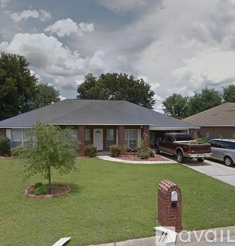 A house with a brown roof and a tree in front of it.