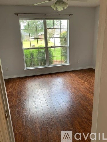 A room with a window and wooden flooring.