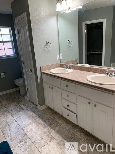 A bathroom with a sink, mirror, and toilet.