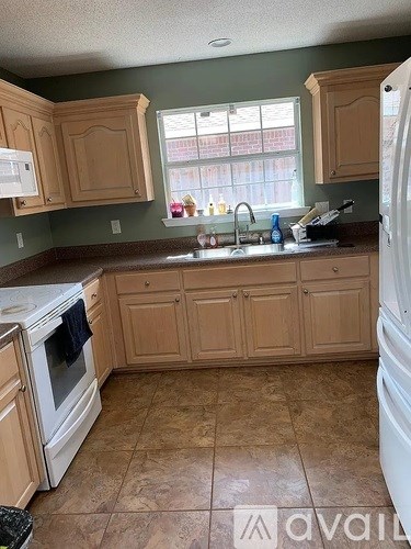 A kitchen with wooden cabinets and a tiled floor.