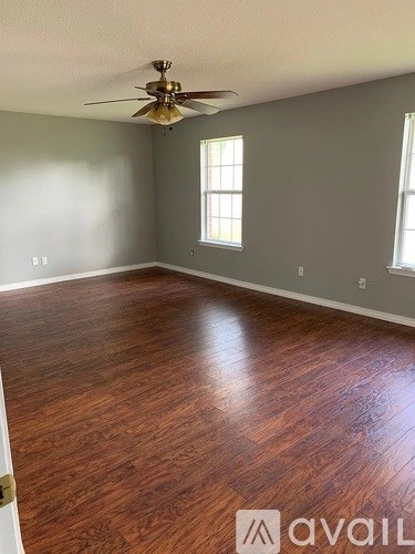 A room with wooden flooring and a ceiling fan.