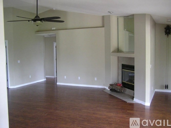 A room with a fireplace and a fan.