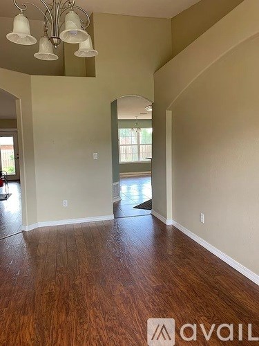 A room with wooden floors and a chandelier.