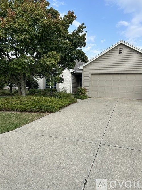 A house with a garage and a driveway in front of it.
