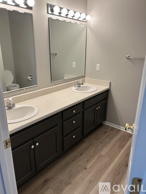 A bathroom with a sink, mirror, and cabinets.