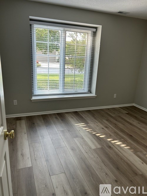 A room with a window and wooden flooring.