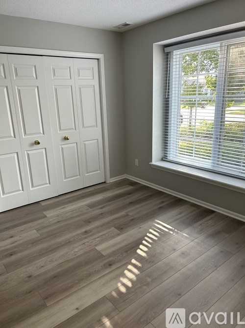 A room with a white door and a window with blinds.