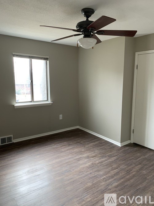 A room with a ceiling fan and a window.