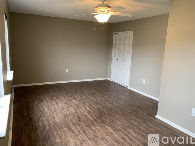 A room with wooden flooring and a ceiling fan.