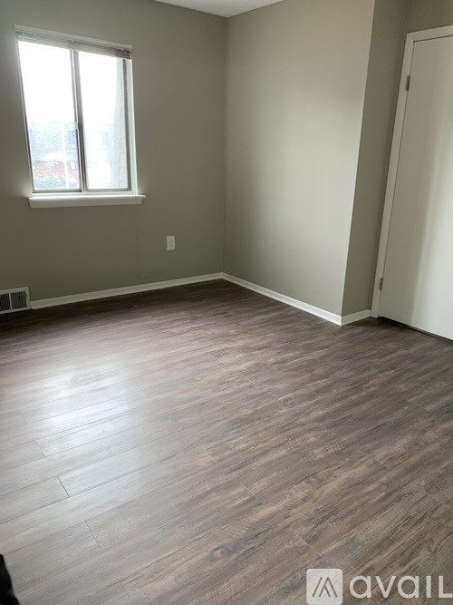 A room with wooden flooring and a window.