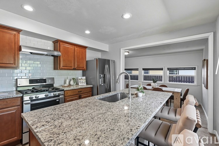A kitchen with granite countertops and wooden cabinets.