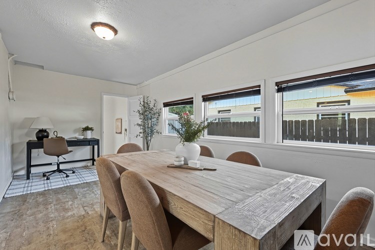 A dining room with a wooden table and chairs.