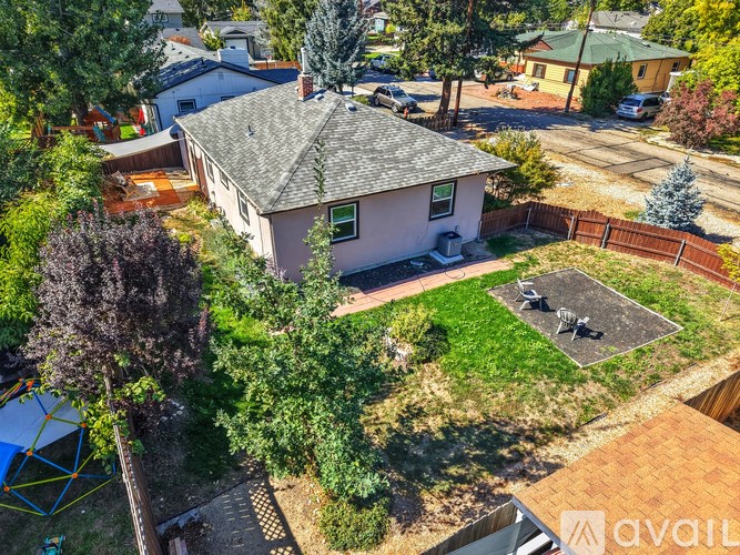 A house with a brown roof and a green lawn in front.
