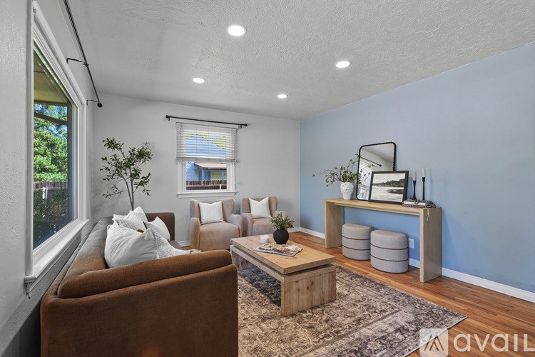 A living room with a brown couch, a wooden coffee table, and a blue wall.
