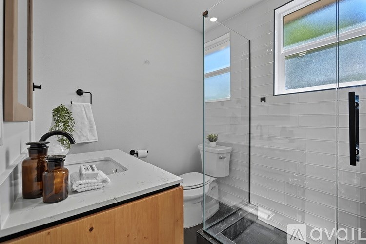 A bathroom with a glass shower door and a window.