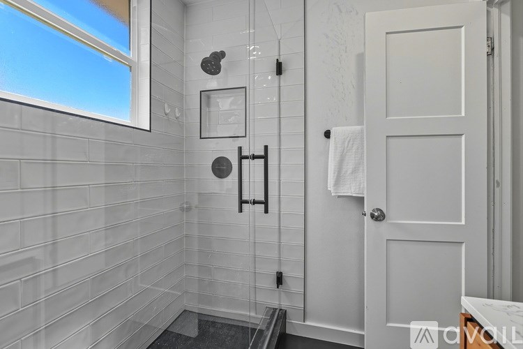 A bathroom with a white door and a window.