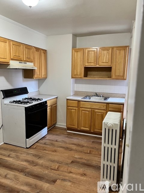 A kitchen with a white stove and wooden cabinets.