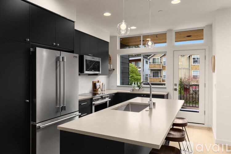 A modern kitchen with a large island and stainless steel appliances.