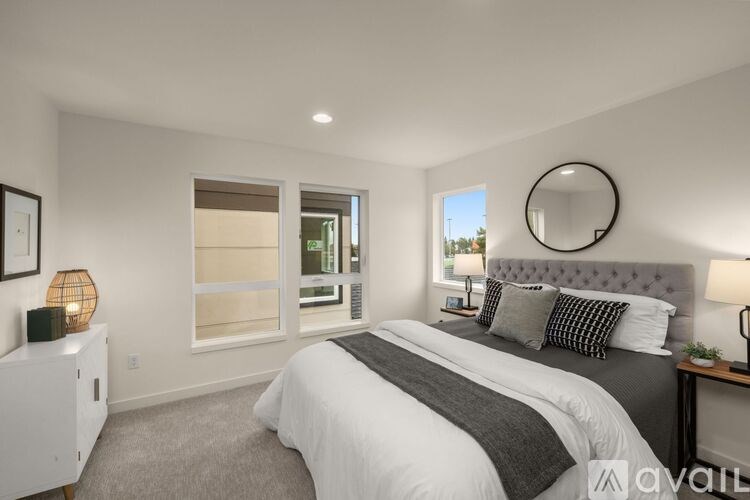 A bedroom with a large bed and a round mirror on the wall.