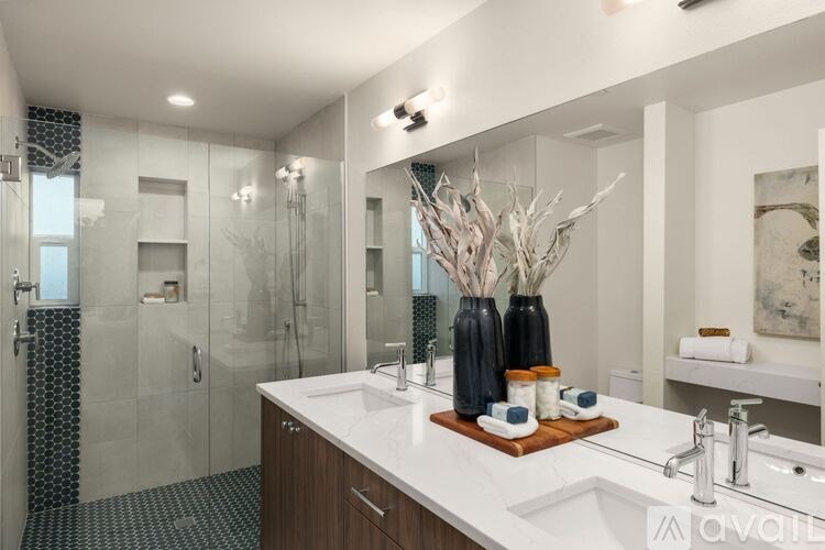A bathroom with a white counter top and a large mirror.