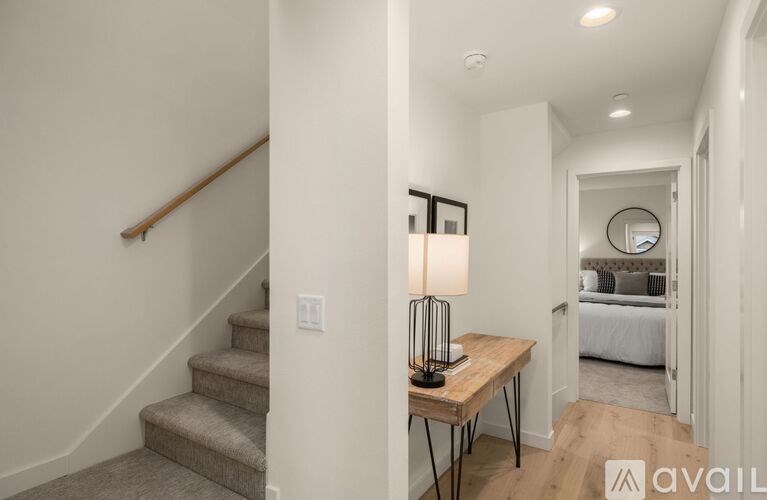 A lamp on a table in a room with a staircase.