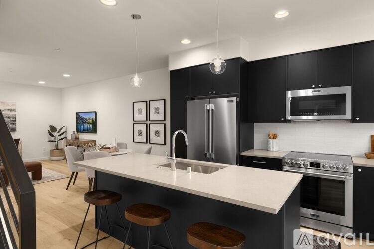 A modern kitchen with a white countertop and black cabinets.