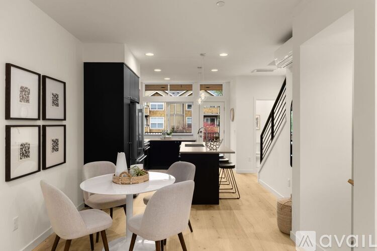 A modern dining room with a white table and chairs.