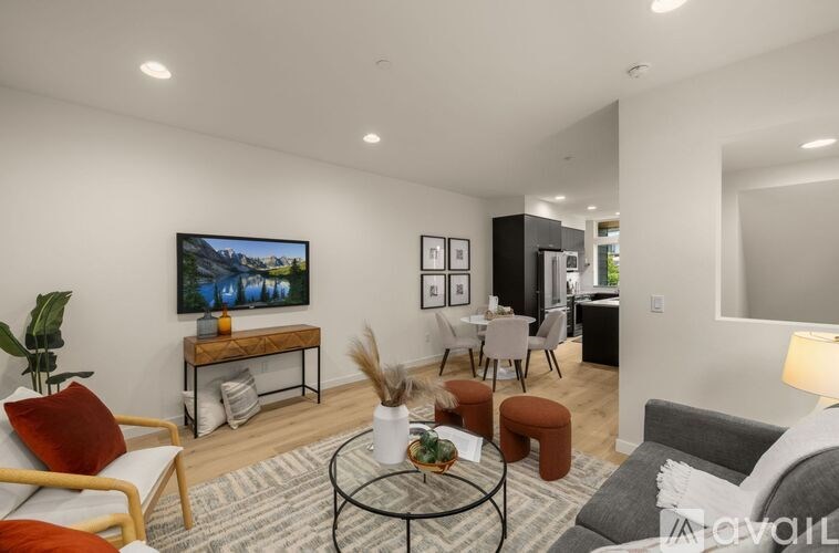 A living room with a sofa, a chair, a coffee table, and a television.