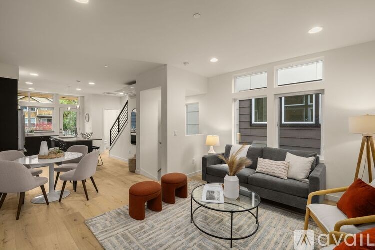 A living room with a grey couch, a coffee table, and a dining table with chairs.