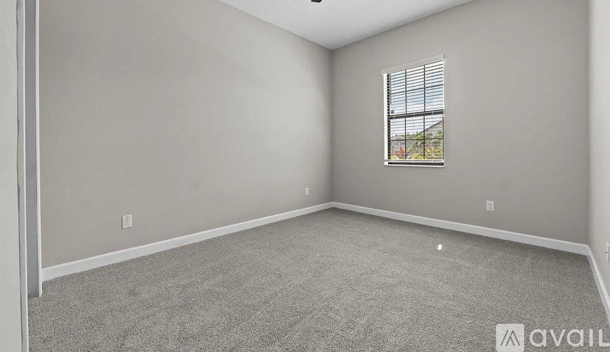 A room with a window and carpeted floor.