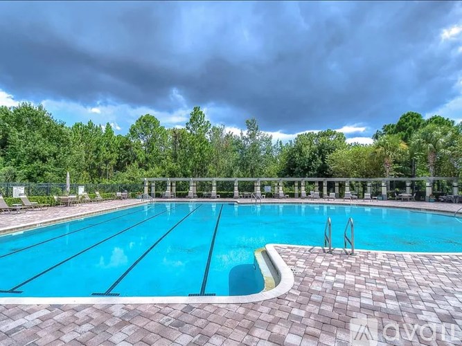 A large outdoor swimming pool surrounded by trees.