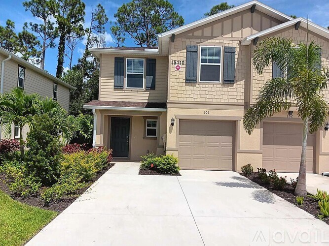 A beige house with a black door and windows.
