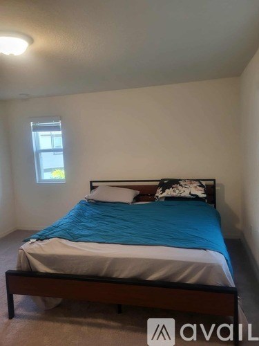 A bedroom with a bed and a window.