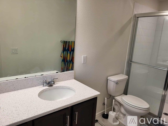 A bathroom with a sink, toilet, and shower.