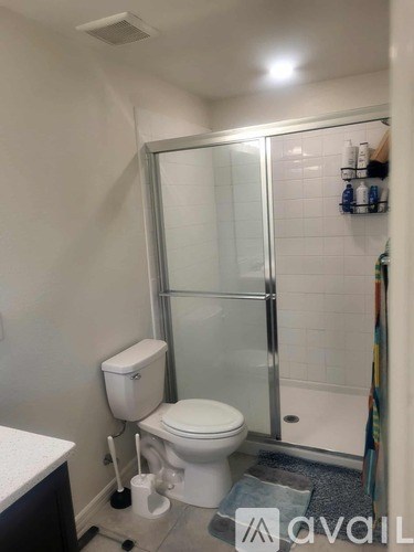 A white toilet with a white tank and a glass shower door.